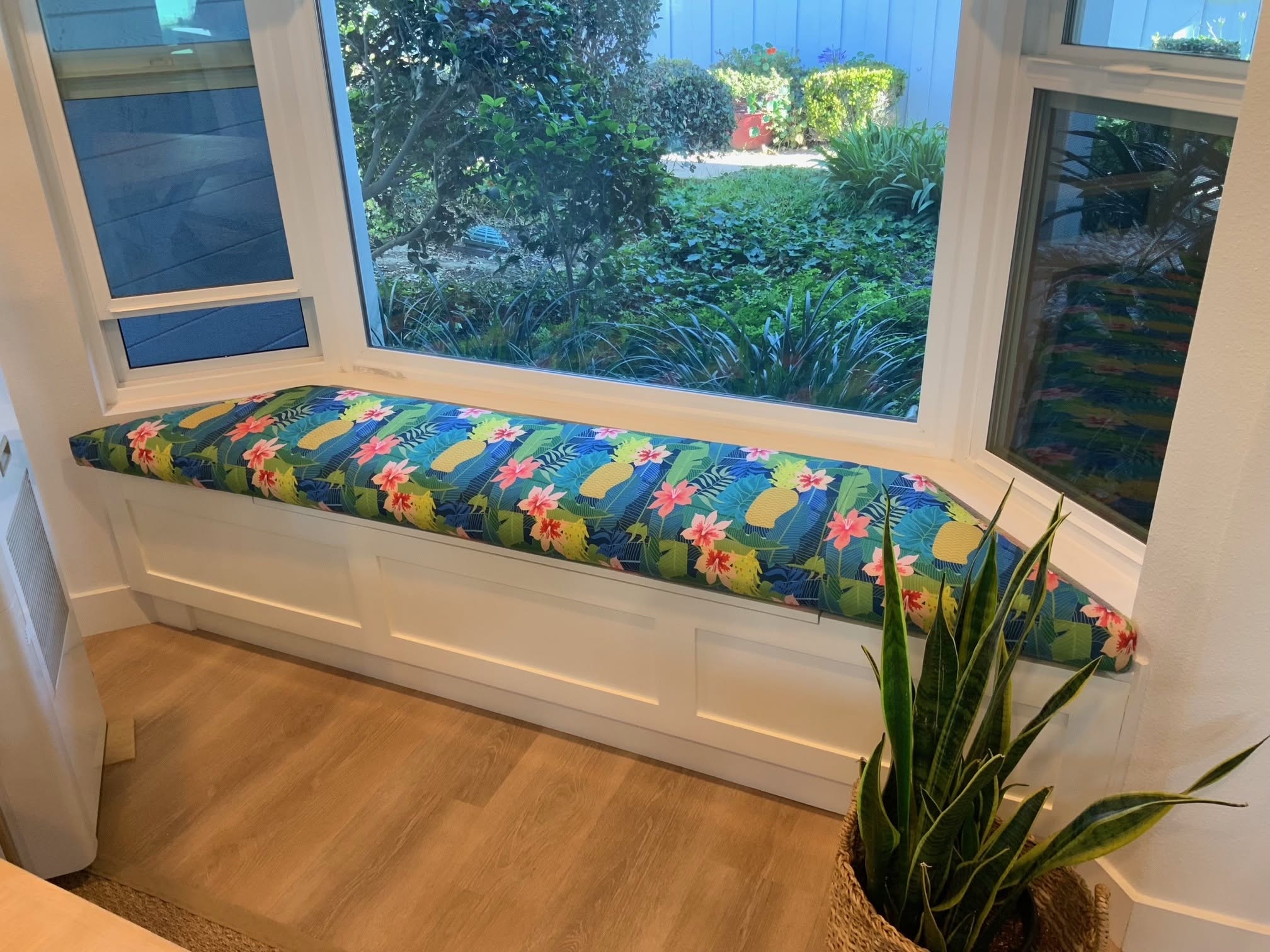 Stationary window banquette with blue, green and red patterned cushion